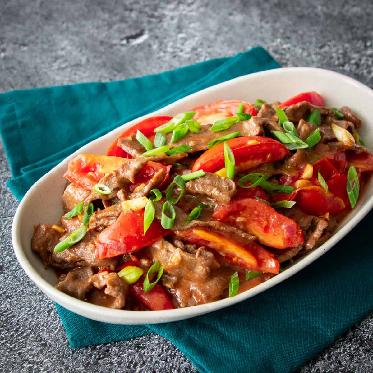 Stir-fried steak and tomatoes over noodles