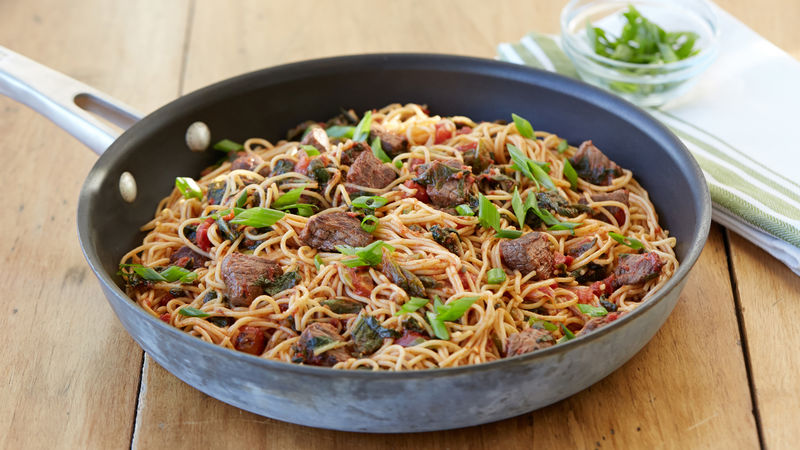 Stir-fried steak and tomatoes over noodles